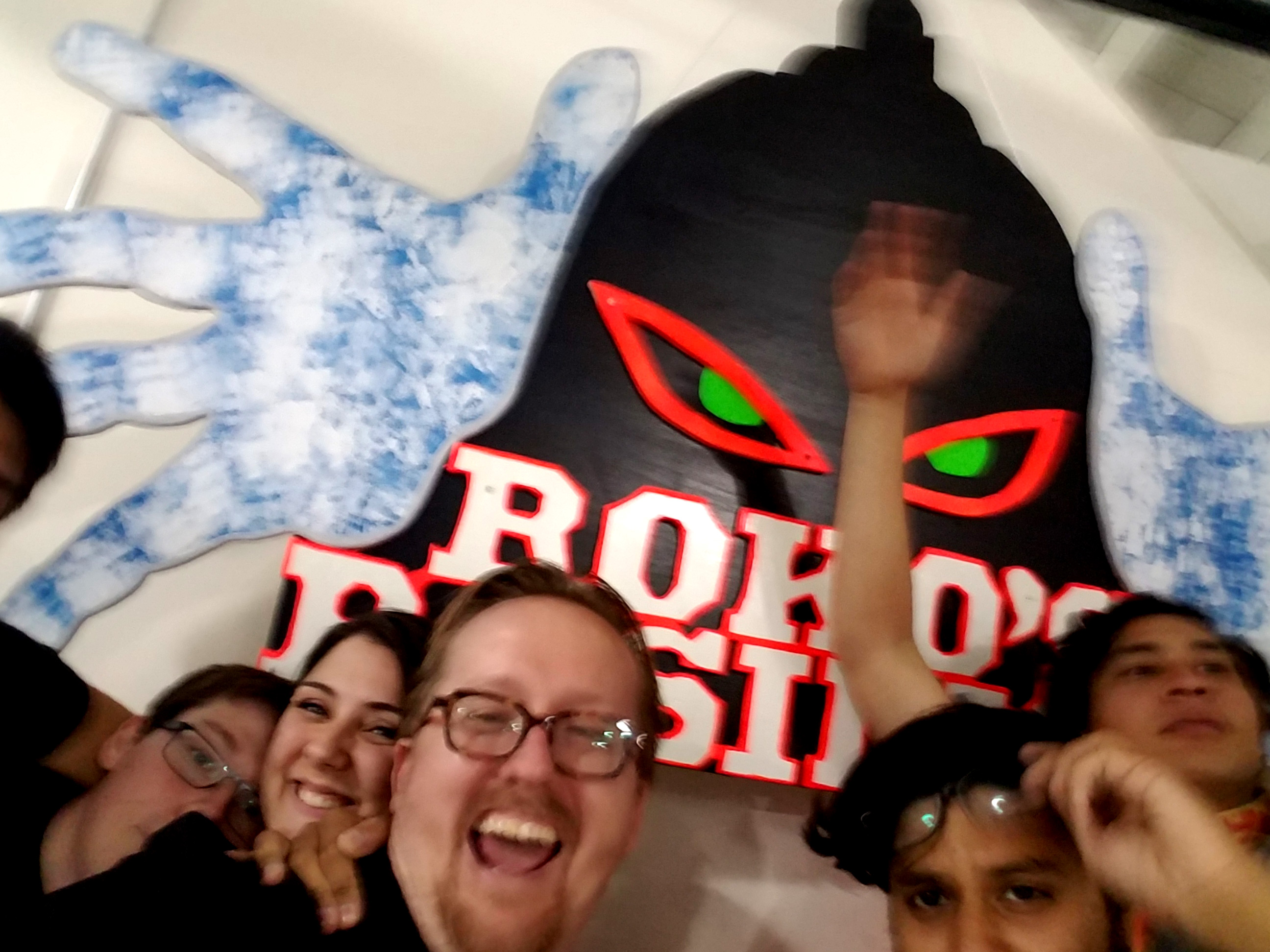 Group selfie in front of sign